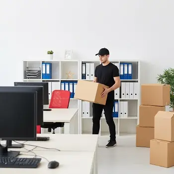 Empleado de mudanza llevando caja de una oficina